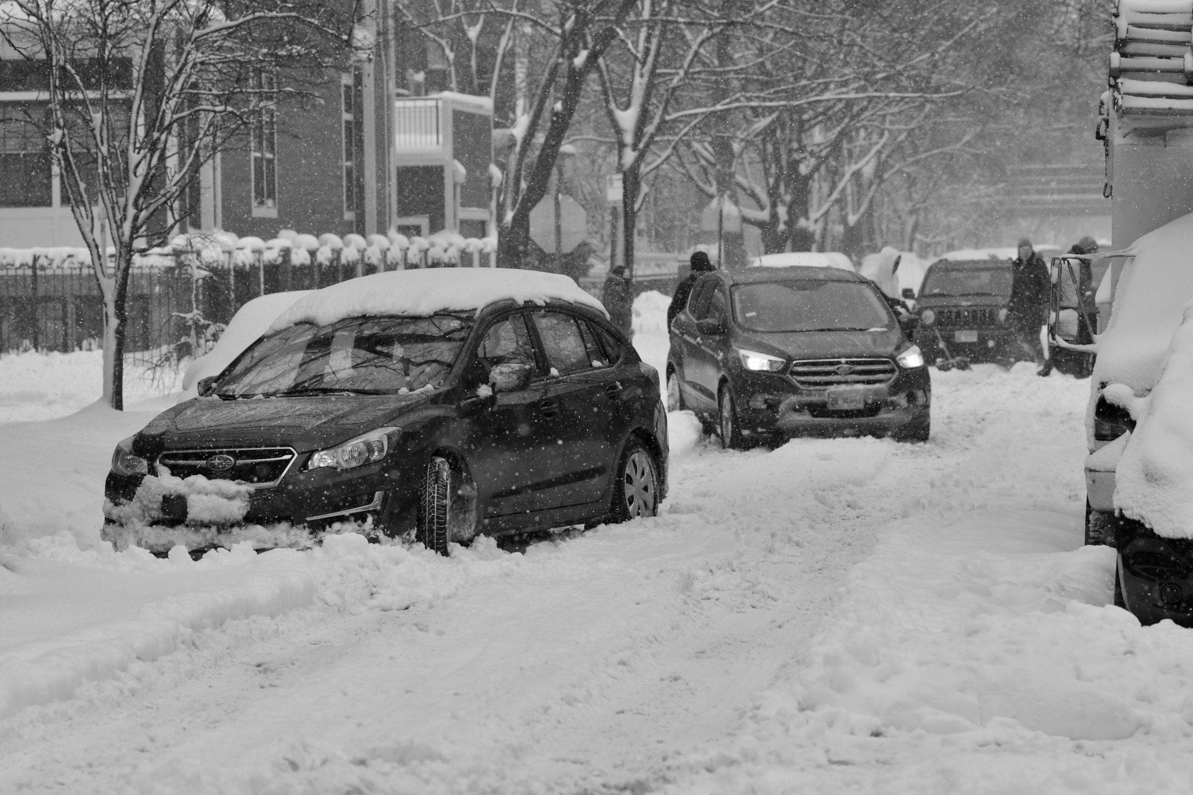 Cars stuck on a snow-covered city street in a winter storm