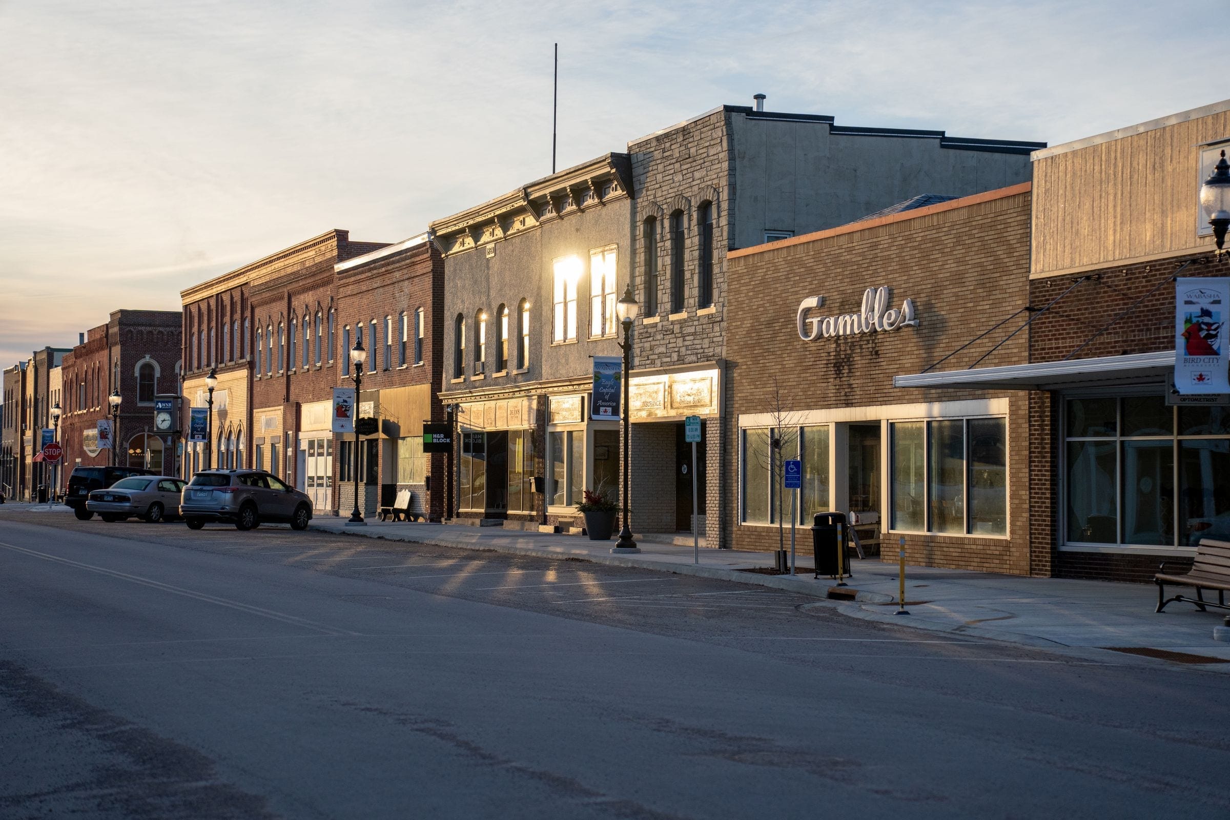 A historic small-town main street with brick storefronts at sunset