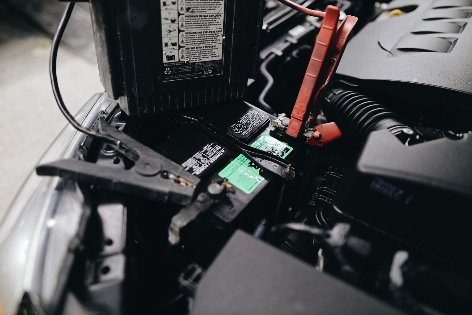 A car battery being jump-started with cables