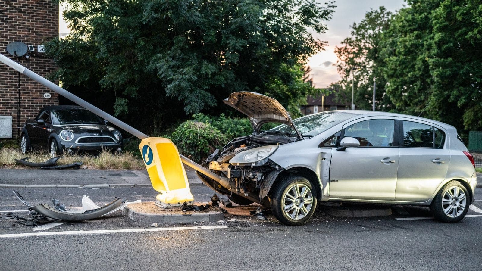 A damaged car that crashed into a lamp post