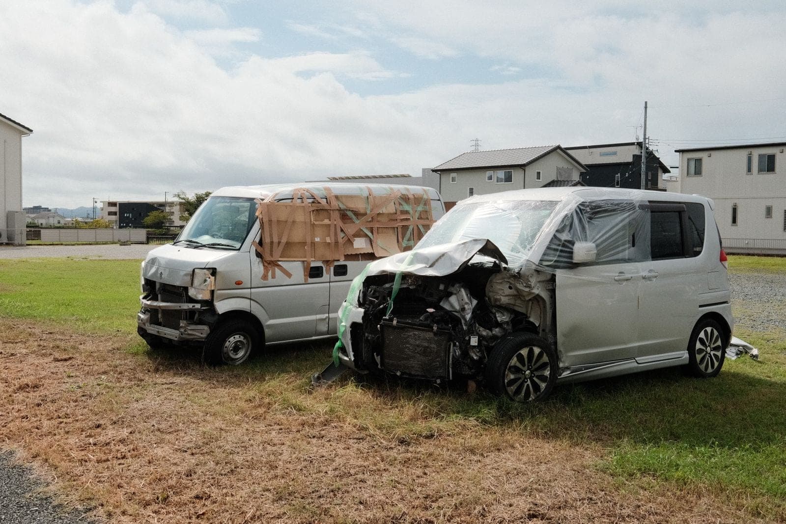 Two wrecked vans parked on a grassy area