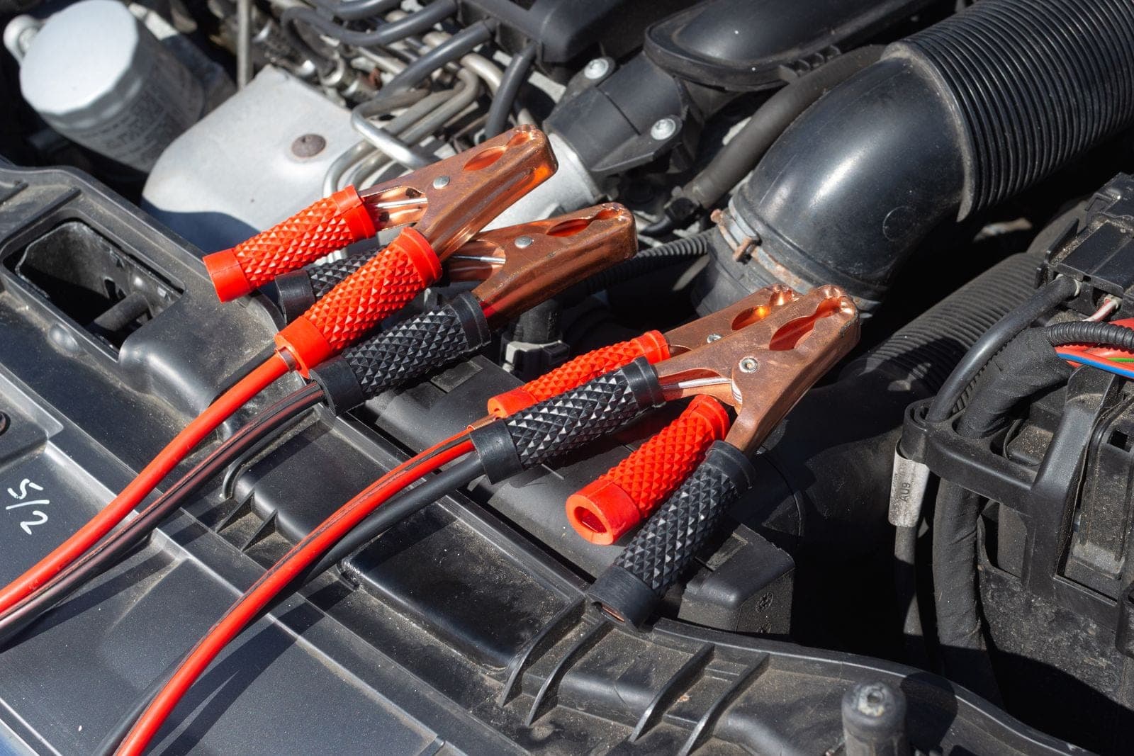 Car engine with attached jump starter cables