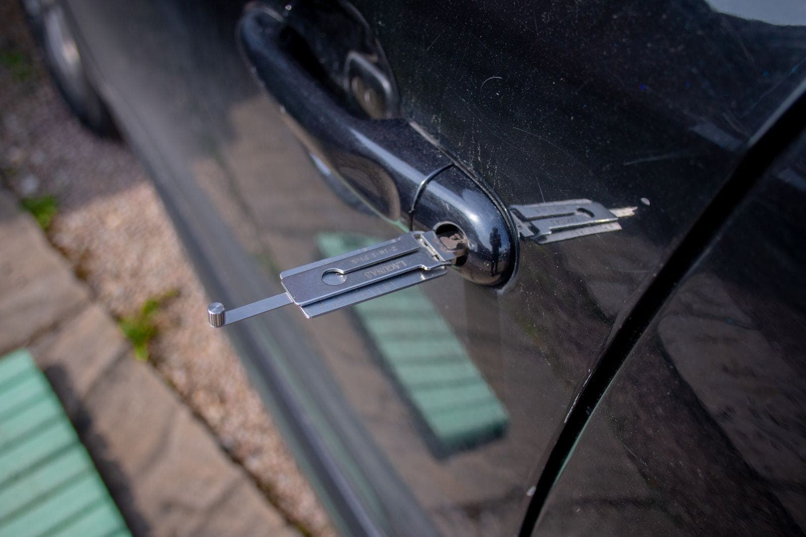 A locksmith tool inserted into a car door lock